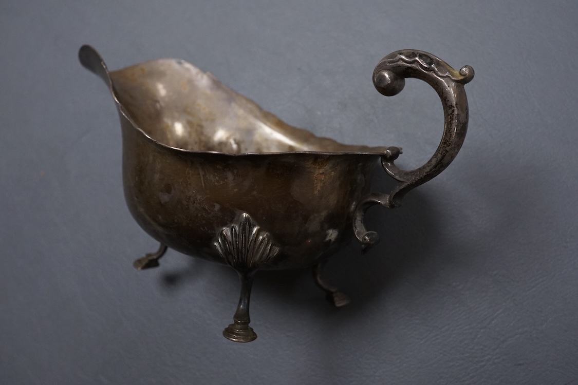 A George V silver sauceboat, with flying scroll handle, Jay, Richard Attenborough Co Ltd, Sheffield, 1925, together with a set of four Edwardian silver napkin rings, 11.3oz.